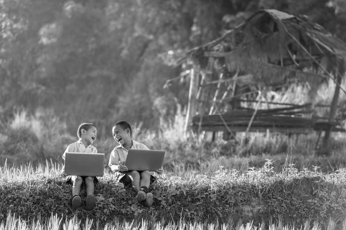 photo-of-two-children-on-laptops-in-nature